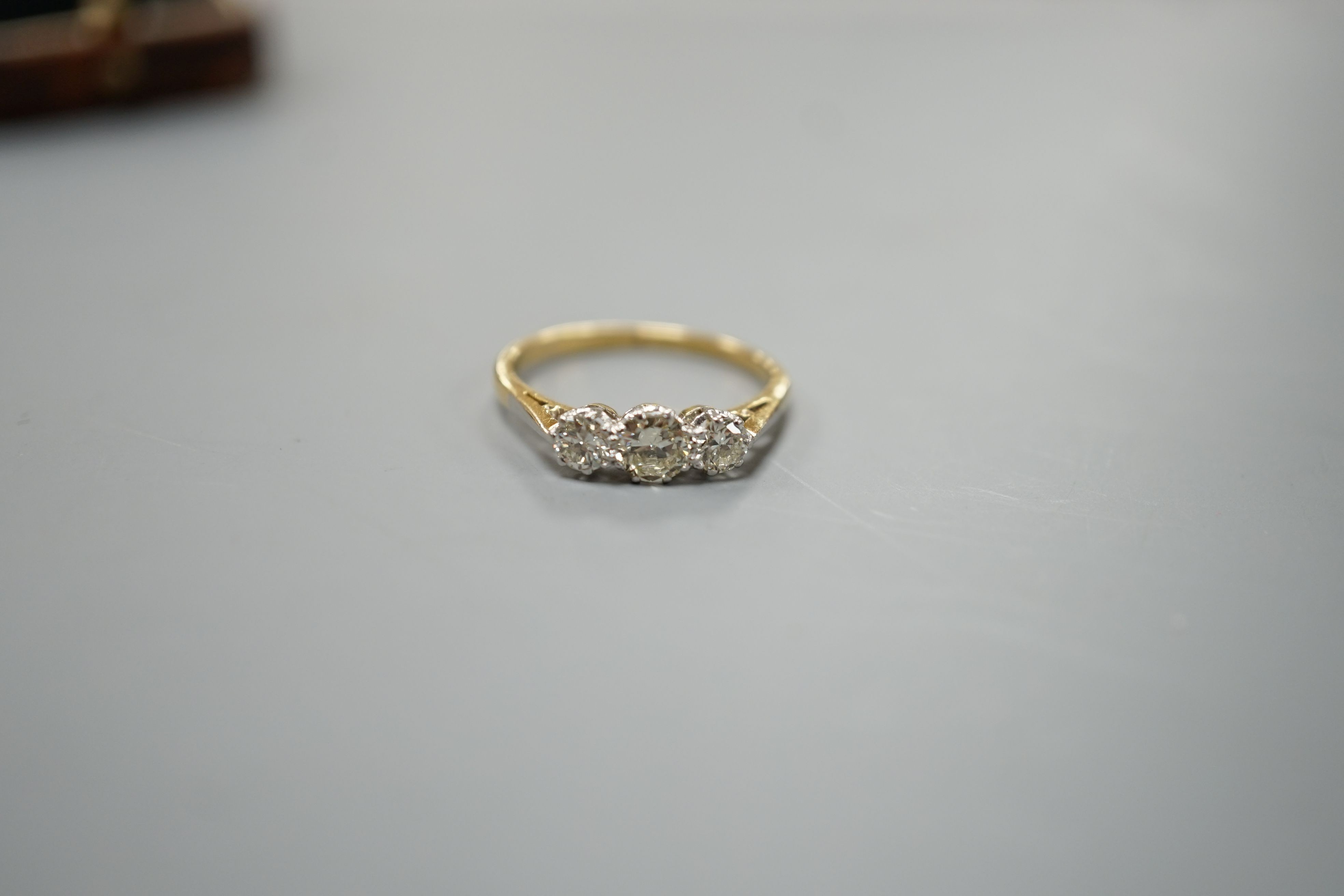 An 18ct gold and platinum three stone diamond ring, size M, gross 2.4 grams.